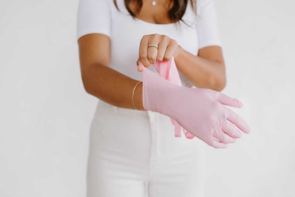Esthetician putting on pink glove